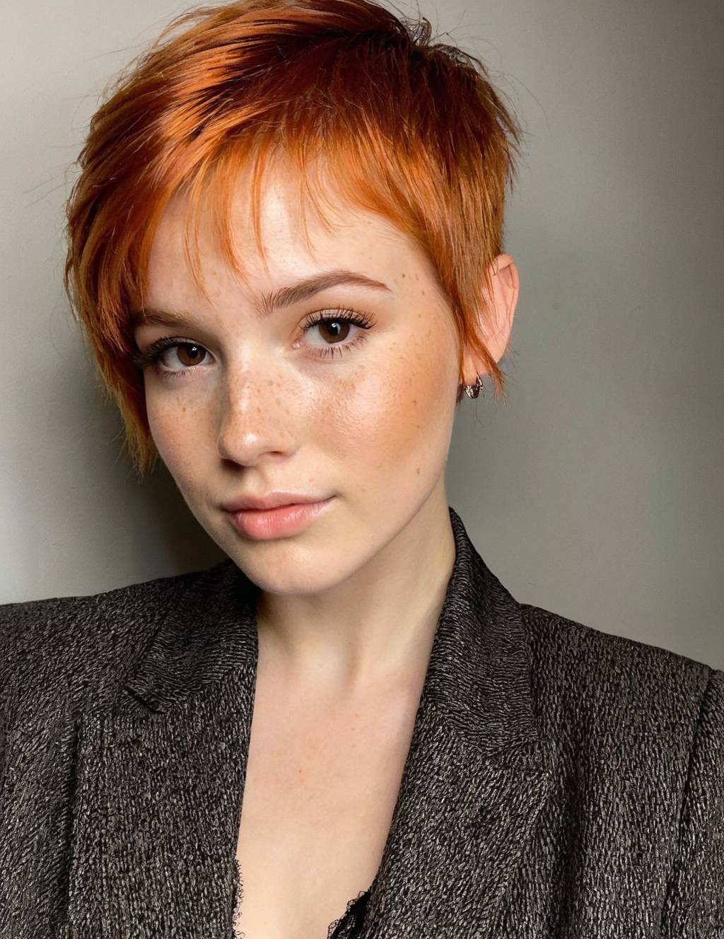 Vibrant copper pixie, natural freckles embraced, professional studio glow—portfolio work that launches beauty careers. See how confident styling choices create magnetic creator content.